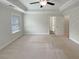 Spacious bedroom featuring a tray ceiling, fan, and ample natural light at 7721 Fawn Cir, Covington, GA 30014