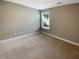 Spacious bedroom with neutral carpeting, a window with neighborhood views, and fresh paint at 7721 Fawn Cir, Covington, GA 30014