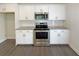 Modern kitchen features stainless steel appliances, white cabinets, subway tile backsplash, and grey countertops at 7721 Fawn Cir, Covington, GA 30014
