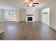 Open-concept living room with hardwood floors, a modern fireplace, and abundant natural light at 7721 Fawn Cir, Covington, GA 30014