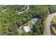 Aerial view showcases a community pool, tennis courts, a playground, and parking surrounded by lush green trees at 1440 Water View Ln, Suwanee, GA 30024