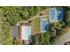 Aerial view showcases a community pool, tennis courts, a playground, and a parking lot nestled among lush green trees at 1440 Water View Ln, Suwanee, GA 30024