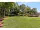 Lush green backyard surrounded by mature trees and landscaping, providing a serene outdoor space at 1440 Water View Ln, Suwanee, GA 30024