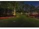 Large backyard with green grass and a trampoline, leading to a deck with stairs and landscaping at 1440 Water View Ln, Suwanee, GA 30024