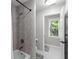 Updated bathroom featuring a tiled shower and updated fixtures with grey walls and a view to the outdoors at 1440 Water View Ln, Suwanee, GA 30024