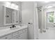 Bright and updated bathroom featuring a vanity with quartz counters and a large mirror at 1440 Water View Ln, Suwanee, GA 30024