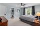 A bedroom with a large window, ceiling fan, neutral carpet, and an ensuite bathroom at 1440 Water View Ln, Suwanee, GA 30024