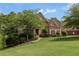 Well-maintained brick home with a manicured lawn and mature trees at 1440 Water View Ln, Suwanee, GA 30024