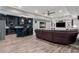 Open concept living room with sleek floors, a partial kitchen, and leather sectional at 1440 Water View Ln, Suwanee, GA 30024