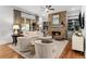 Cozy living room with a stone fireplace, neutral furniture, and large windows overlooking a wooded area at 1440 Water View Ln, Suwanee, GA 30024