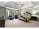 Spacious main bedroom has a tray ceiling, ceiling fan, and large windows that let in plenty of natural light at 1440 Water View Ln, Suwanee, GA 30024