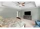 Comfortable main bedroom features neutral walls, a ceiling fan, and a large TV above a rustic cabinet at 1440 Water View Ln, Suwanee, GA 30024