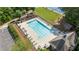 Aerial view of a large pool with lounge chairs, playground, parking, and a clubhouse surrounded by lush trees at 1440 Water View Ln, Suwanee, GA 30024