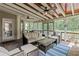 Covered screened in porch with comfortable seating, ceiling fans, and wooded backyard views at 1440 Water View Ln, Suwanee, GA 30024