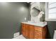 Stylish bathroom with wood vanity, quartz countertop, round mirror, decorative floral arrangement, and light gray accent wall at 1627 Rex Dr, Marietta, GA 30066