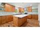 Spacious kitchen featuring a large island, wood cabinetry, white countertops, stainless appliances, and hardwood floors at 1627 Rex Dr, Marietta, GA 30066