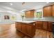 Modern kitchen with a large island, wood cabinets, white countertops, stainless appliances, and beautiful hardwood flooring at 1627 Rex Dr, Marietta, GA 30066