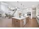 A modern, open kitchen with a large island, stainless steel appliances, and hardwood floors overlooks a living area with fireplace at 2505 Kirkwood Dr, Cumming, GA 30041