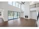 A modern living room with hardwood floors, a fireplace, and large windows overlooking the backyard at 2505 Kirkwood Dr, Cumming, GA 30041