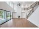 A modern living room with hardwood floors, a fireplace, and large windows overlooking the backyard and staircase at 2505 Kirkwood Dr, Cumming, GA 30041