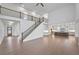 Open-concept living room with hardwood floors, a staircase, and a view of the modern kitchen at 2505 Kirkwood Dr, Cumming, GA 30041