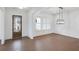 A room with hardwood floors, a light fixture, and a view of the front yard through a large window at 2505 Kirkwood Dr, Cumming, GA 30041