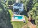 Aerial view of the home featuring a spacious backyard, in-ground pool, deck, and mature trees at 300 Bermuda Ct, Dallas, GA 30157