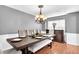 Dining room area features a large wooden table, elegant chandelier, and natural light at 300 Bermuda Ct, Dallas, GA 30157