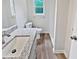Bathroom featuring new vanity, granite countertop, new flooring, and a window at 527 Tomahawk Trl, Woodstock, GA 30188