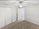 This bedroom has neutral carpet, a ceiling fan, wainscoting, and a closet for ample storage at 527 Tomahawk Trl, Woodstock, GA 30188