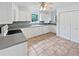Well-lit kitchen with white cabinets, tile flooring, and plentiful counter space at 527 Tomahawk Trl, Woodstock, GA 30188