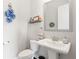 Charming powder room with pedestal sink, decorative mirror, and neutral color palette at 10200 Windalier Way, Roswell, GA 30076