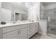 Modern bathroom featuring a double vanity with white cabinetry and a large, tiled walk-in shower at 10200 Windalier Way, Roswell, GA 30076