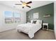 Comfortable bedroom with a green accent wall, white furniture, a ceiling fan, and a window at 10200 Windalier Way, Roswell, GA 30076
