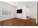Bedroom with hardwood floors, large window with shutters, and TV on the wall at 10200 Windalier Way, Roswell, GA 30076