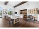 Dining area featuring wood floors, large table, bar with a kitchen area, and brick wall accents at 10200 Windalier Way, Roswell, GA 30076