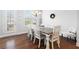 Well-lit dining area with white table and six chairs offers backyard views at 10200 Windalier Way, Roswell, GA 30076