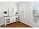 Welcoming entryway featuring a decorative mirror cabinet with decorative plants and shutters at 10200 Windalier Way, Roswell, GA 30076