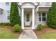 Charming entrance with columns, sage-colored door, and meticulous landscaping, creating a warm curb appeal at 10200 Windalier Way, Roswell, GA 30076