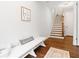 Hallway featuring stairs with wood treads, a white bench, and decor at 10200 Windalier Way, Roswell, GA 30076