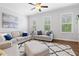 Sun-filled living room with neutral decor, large windows, and comfortable seating creates a relaxing atmosphere at 10200 Windalier Way, Roswell, GA 30076