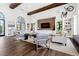 An elegant living room with hardwood floors, exposed beams, stylish decor, and comfortable seating arrangements at 10200 Windalier Way, Roswell, GA 30076