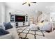 Bright living room with ceiling fan features stylish furniture and decor, a TV, and staircase to upper level at 10200 Windalier Way, Roswell, GA 30076