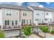 Townhome rear view featuring private decks, lower level garages, and manicured landscaping at 10200 Windalier Way, Roswell, GA 30076
