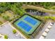 Aerial view of well-maintained tennis courts with a pond and green surroundings at 10200 Windalier Way, Roswell, GA 30076