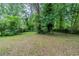 Large, grassy backyard offers a serene, natural environment with mature trees at 3140 Delowe Dr, Atlanta, GA 30344