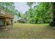 Spacious backyard view with mature trees, and partial view of raised deck at 3140 Delowe Dr, Atlanta, GA 30344
