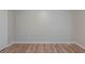 Empty bedroom with hardwood flooring, neutral paint, base trim, and a white door at 3140 Delowe Dr, Atlanta, GA 30344