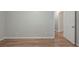 Empty bedroom with hardwood flooring, neutral paint, base trim, and a white door at 3140 Delowe Dr, Atlanta, GA 30344