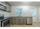 Well-lit kitchen with granite countertops, gray cabinets, stainless steel appliances, and white subway tile backsplash at 3140 Delowe Dr, Atlanta, GA 30344